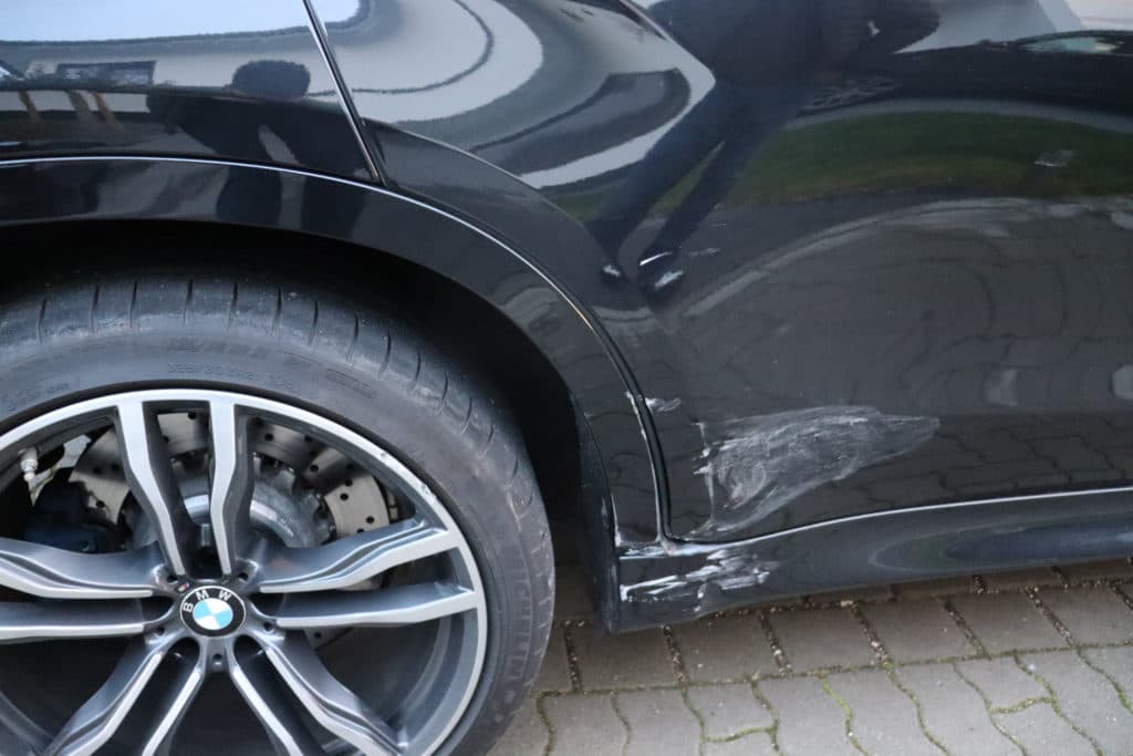 Seitlicher Streifschaden an einem schwarzen BMW