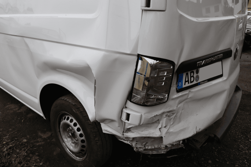 Unfallschaden am Heck eines weißen Transporters